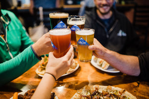 Cheers with Eddyline beers over pizza